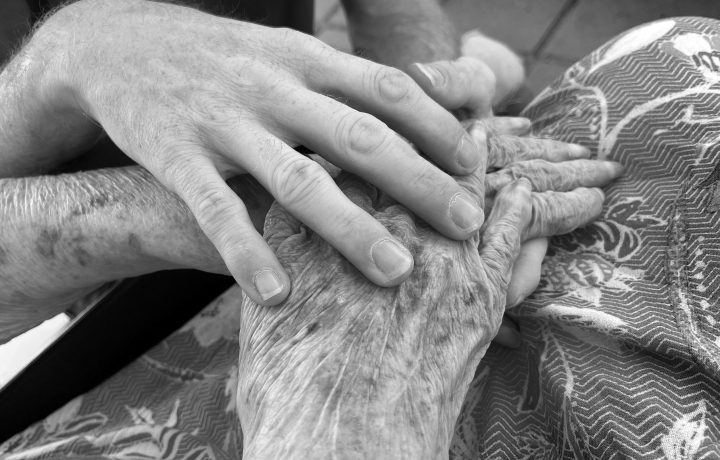 Pflegekraft begleitet Seniorin im Alltag